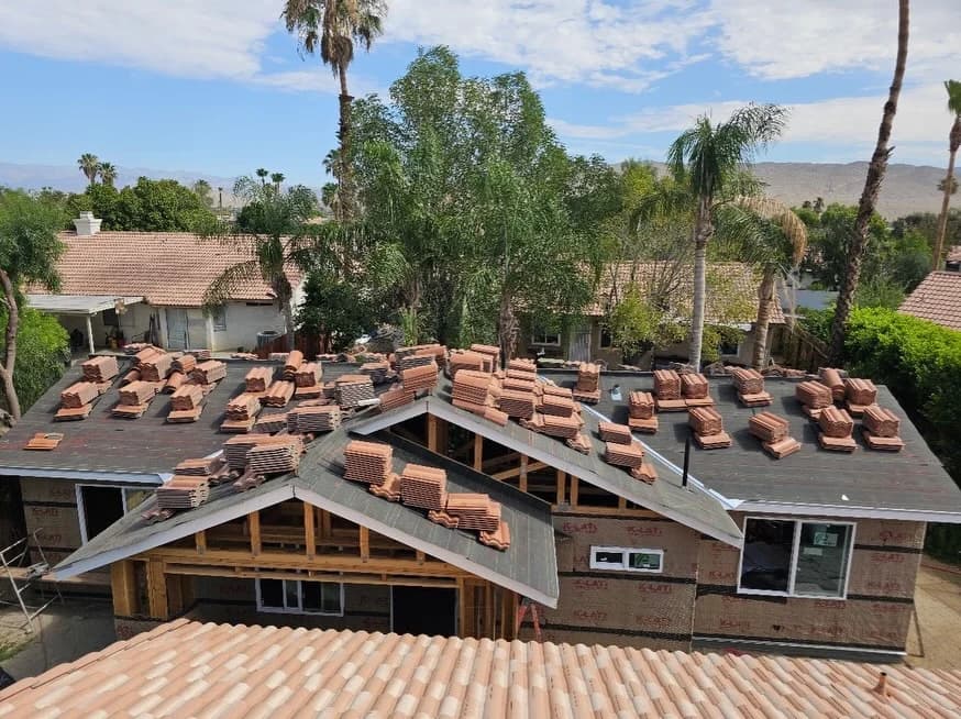 Curved tiles stacked on roof underlayment during installation.